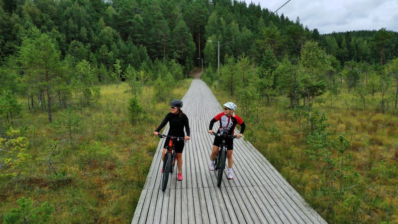 Kaksi pyöräilijää maastoreitillä.